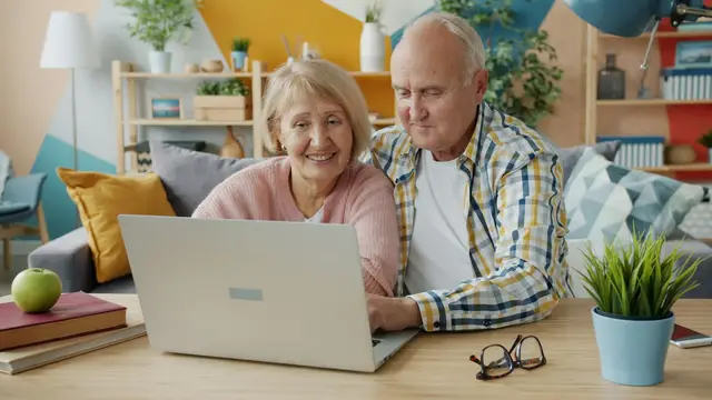 An older couple reviewing options on a laptop at home