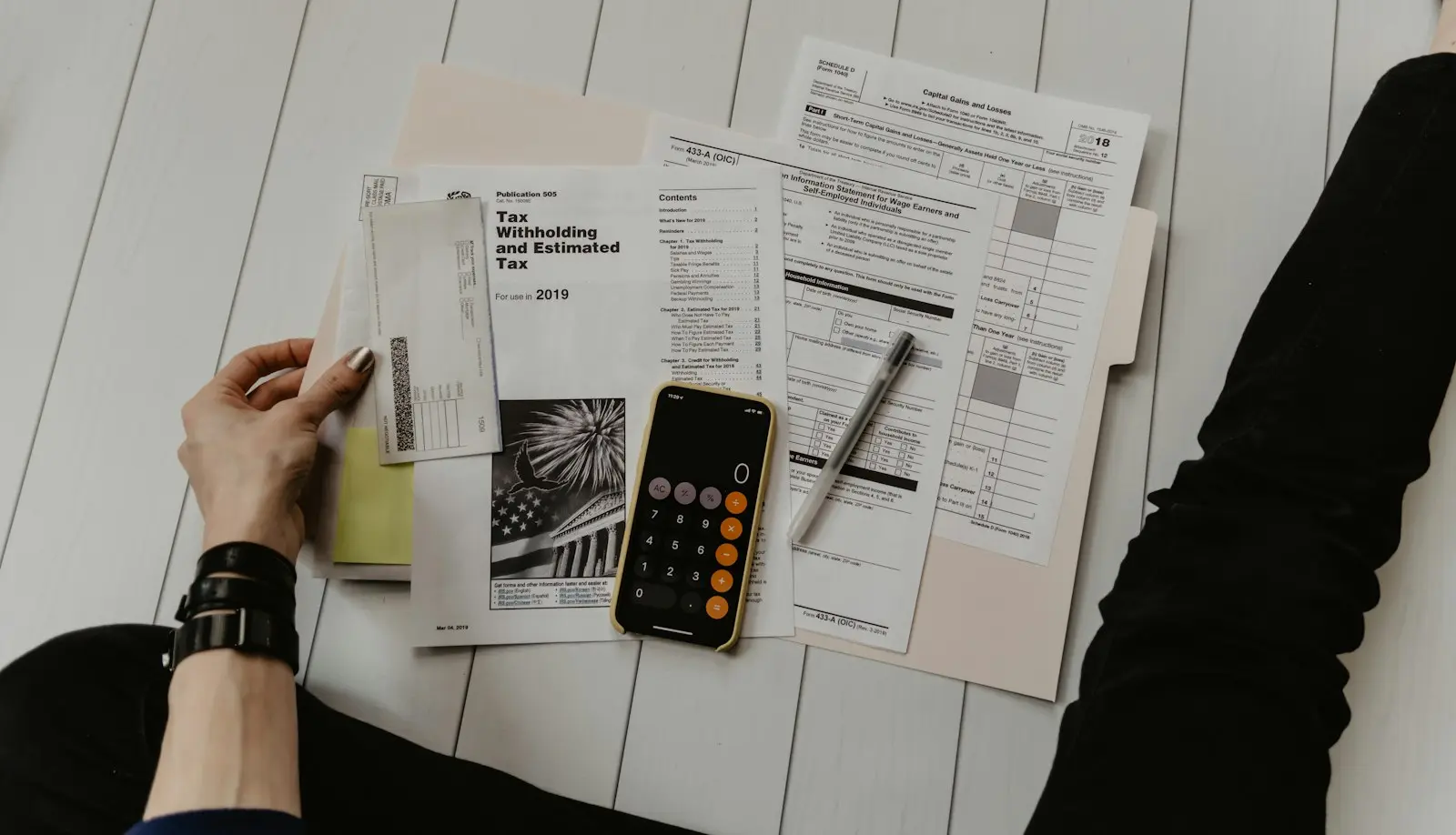 Tax forms, a calculator and a pen on a desk